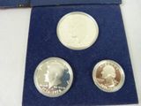 two silver and gold coins in a blue case on a white surface