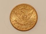 a close up of a gold coin on a white surface
