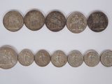 several coins are arranged in a row on a white surface