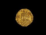une pièce d'or sur laquelle figure une couronne, sur fond noir
