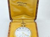 an antique pocket watch in a wooden case with a yellow lining