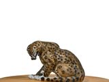 figurine of a leopard sitting on a round wooden table