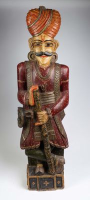 figurine en bois représentant un homme coiffé d'un turban et tenant une pipe