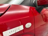 a close up of a red car with a sticker on it