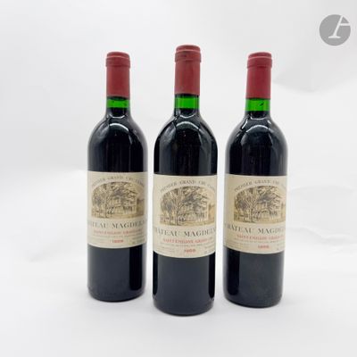 trois bouteilles de vin rouge posées l'une à côté de l'autre sur une surface blanche