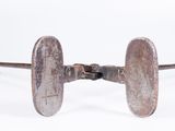 a metal object with a wooden handle on a white surface