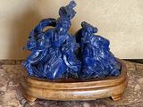une figurine bleue posée sur un socle en bois, sur une table