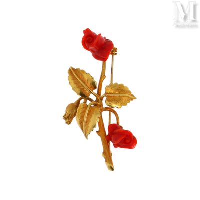 une broche en forme de fleur dorée et rouge sur fond blanc