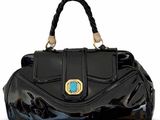 Le sac à main noir est orné d'une pierre turquoise en son centre.