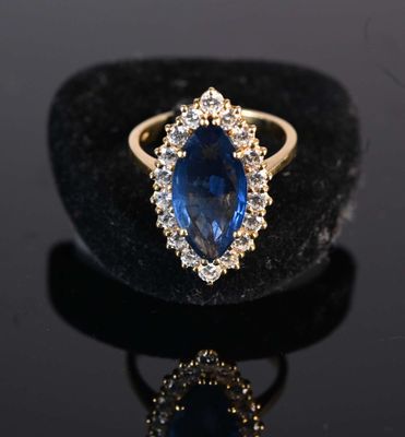 a close up of a blue sapphire and diamond ring on a black surface