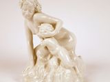 une statue représentant une femme assise sur une souche d'arbre
