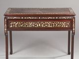 une petite table avec un plateau en bois orné d'un motif floral