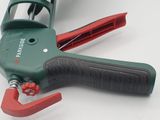 a close up of a green and red hand held tool