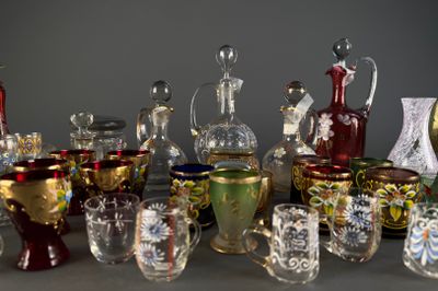 de nombreux vases et verres en verre de différentes couleurs sur la table