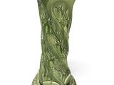 un vase vert posé sur une table blanche