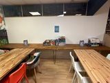 many tables and chairs in this room with wood floors