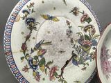 two plates and a bowl sitting on a table
