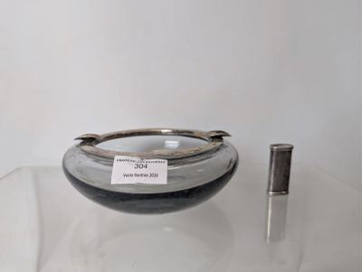 a glass bowl sitting on a table with a pen in it
