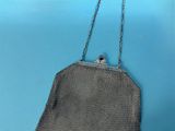 an antique silver mesh purse with a chain strap and clasp
