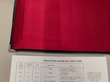 someone is holding a silver coin in a black box with a red cloth