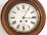 a wooden clock with roman numerals on the face