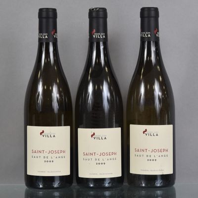 three bottles of wine are lined up on a glass table