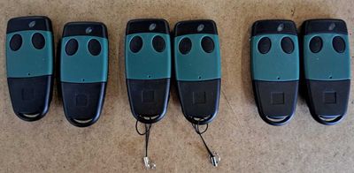 six remotes are lined up on a table with a keychain