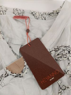 un gros plan d'une chemise blanche avec une étiquette marron