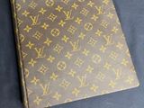 a louis vuitton notebook on a table with a price tag