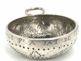 a silver bowl with writing on it on a white surface