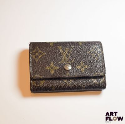 Portefeuille Louis Vuitton posé sur une surface blanche, sur fond blanc
