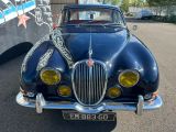 une voiture bleue à laquelle était attachée une chaîne, garée sur un parking