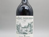 une bouteille de vin rouge posée sur une table blanche