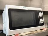 un micro-ondes posé sur une cuisinière dans une cuisine