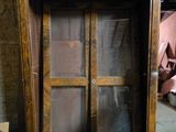 un meuble en bois avec une porte en verre au milieu d'une pièce