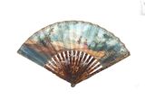 a fan with a painting on it sitting on a table