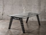 une photo d'une table en verre et en métal dans une pièce en béton