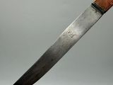 a close up of a knife with a wooden handle on a gray background