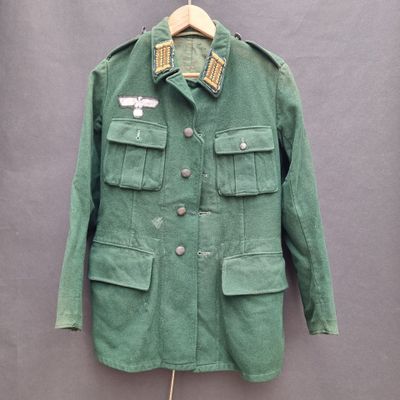 an old green jacket with a patch on the collar and buttons