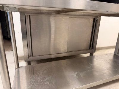 une table en acier inoxydable munie d'une porte sur le dessus