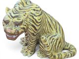 a statue of a tiger sitting on a white surface