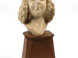 a close up of a bust of a woman on a wooden pedestal