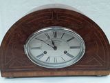 une petite horloge en bois avec des chiffres romains