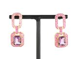 une paire de boucles d'oreilles ornées de pierres roses et de cristaux roses