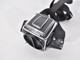 an old camera on a white surface with a strap around it