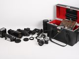 une mallette noire contenant un appareil photo et plusieurs autres objets