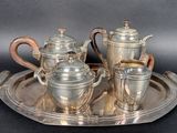 a silver tray with a silver tea set on it