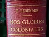 a red book with gold writing on it sitting on a shelf