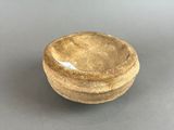 a close up of a wooden bowl on a gray surface