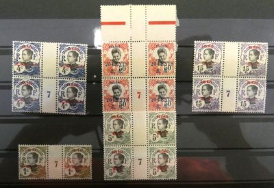 Plusieurs timbres sont exposés dans une vitrine posée sur une table